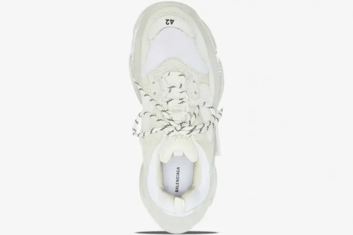 Top-down view of a white Balenciaga Triple S sneaker featuring a clear sole and black-and-white laces. - SKU 544351W2FB19000