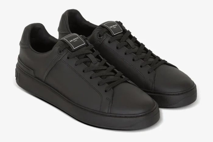 Pair of black Balmain B-Court calfskin trainers shown from a three-quarter front angle. - SKU GM1VI288LVTR