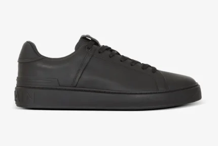 Side profile view of a Balmain B-Court trainer in black calfskin leather with matching black laces. - SKU GM1VI288LVTR