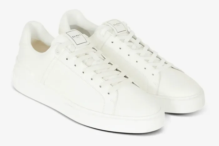 Pair of white Balmain B-Court calfskin trainers shown from a three-quarter front angle. - SKU GM1VI288LVTR