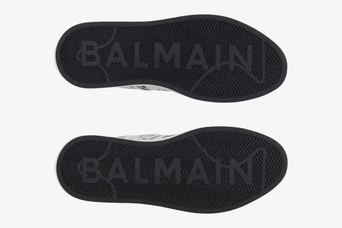 Bottom view of Balmain B-Court white low-top sneakers showing black rubber soles with embossed logo. - SKU EN1VI690LCLP