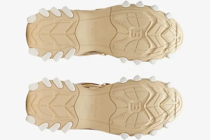 Bottom view of Balmain B-East B3V27 sneakers in beige and gold showing the textured rubber soles. - SKU B3V27