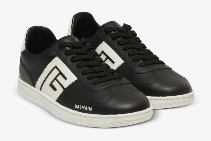 A pair of black and white Balmain Calfskin Swan Trainers in a three-quarter front view. - SKU EM0VI360LVTR