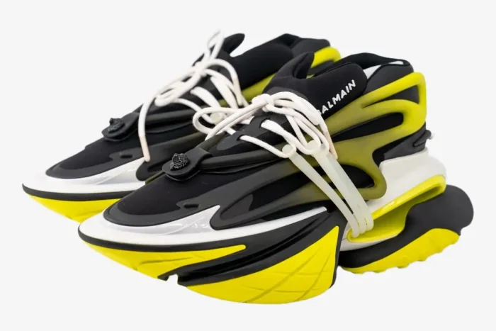 Balmain Unicorn low-top sneakers in black and yellow, three-quarter front view on white background. - SKU YM0VJ309KNET