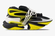 Side view of Balmain Unicorn low-top sneakers in black and yellow with a chunky futuristic sole. - SKU YM0VJ309KNET