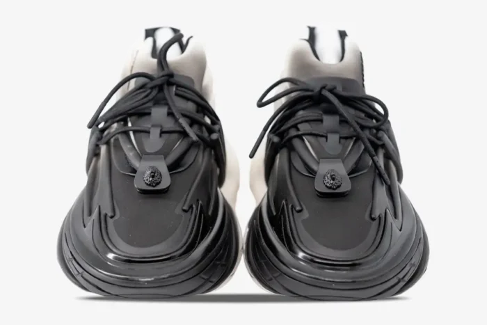 Front view of Balmain Unicorn Low Top sneakers in white and black gradient with lion head detail. - SKU YM0VJ309KNED-GAB