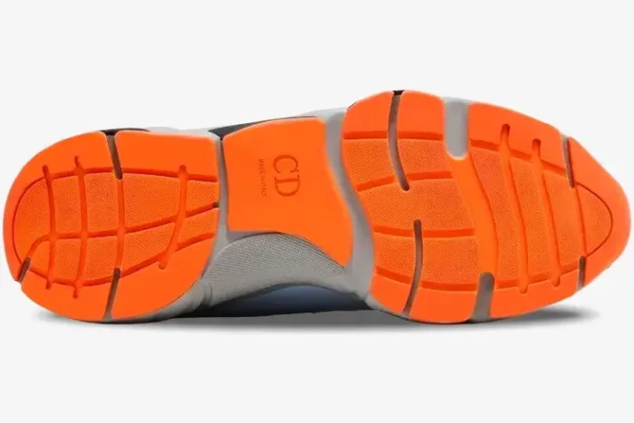 Bottom view of the Dior B22 sneaker featuring a bright orange segmented rubber outsole with CD logo. - SKU 3SN231YKA_H061
