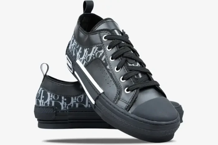 Dior B23 Low Top Oblique Canvas sneakers in black and grey, shown from a three-quarter front perspective. - SKU 3SN249YNT_H960