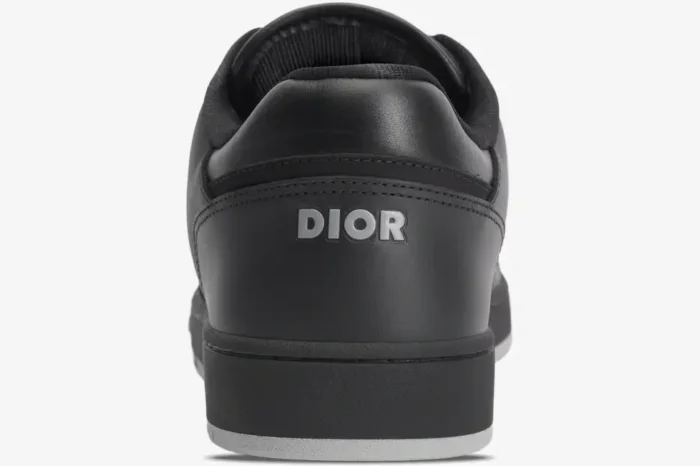 Back view of a Dior B27 Low Top sneaker in black leather with silver Dior logo on the heel. - SKU 3SN272ZPR_H969