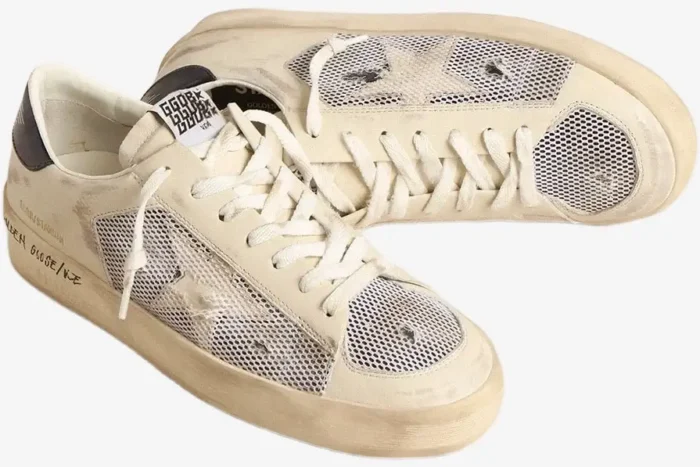 White distressed Golden Goose Stardan sneakers with mesh panels and star logo from a side perspective. - SKU GMF00580.F004567.10768