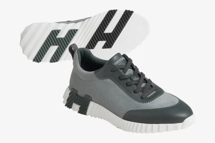 Hermès Bouncing Sneaker in grey and white, showing side profile and H-patterned sole. - SKU H231763ZH6I400