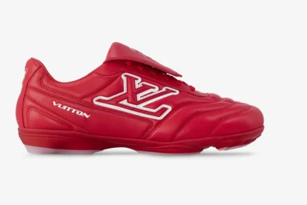 Side profile of a red leather Louis Vuitton Footprint soccer shoe with white LV logo.