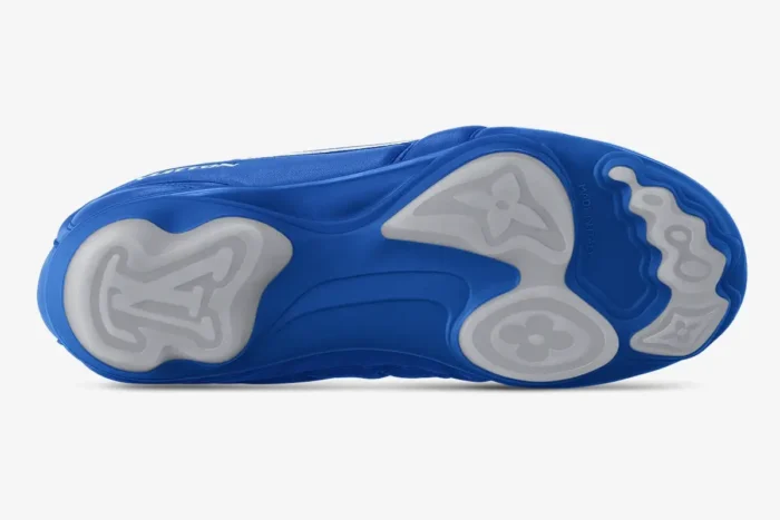 Bottom sole of blue Louis Vuitton Footprint soccer shoes showing monogram traction pods.