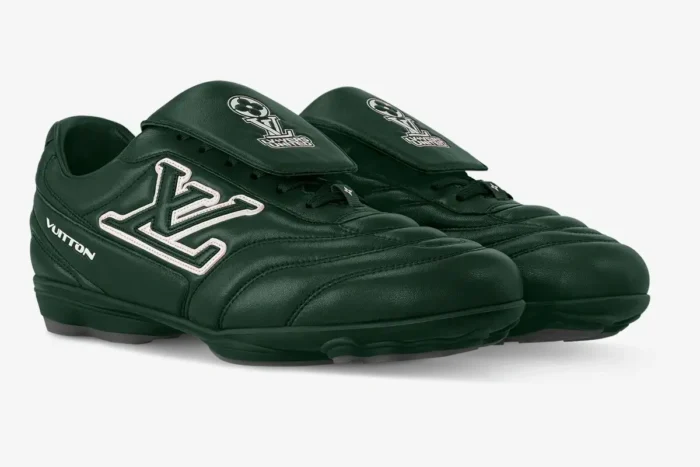 Louis Vuitton Footprint Soccer Shoes in dark green, three-quarter view, featuring white LV logo and fold-over tongue.