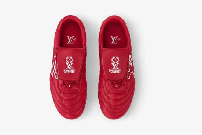 Top-down view of red leather Louis Vuitton Footprint soccer shoes with white logo details.