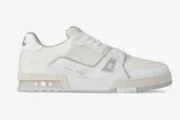 Side profile of white Louis Vuitton LV Trainer #54 leather sneakers with signature script. - SKU 1ADERB