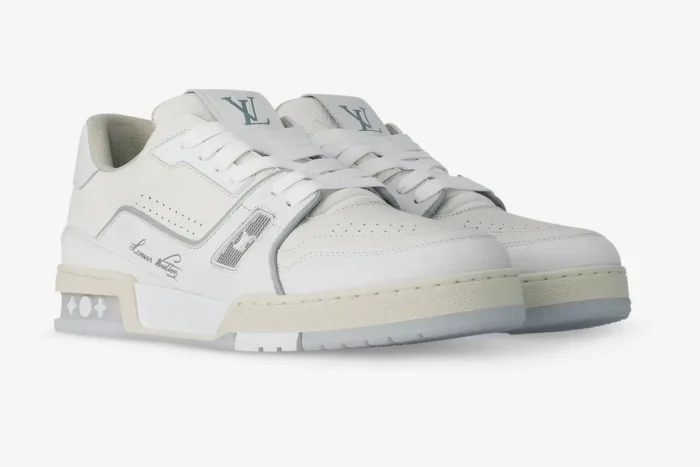 Pair of Louis Vuitton LV Trainer #54 white leather sneakers from a three-quarter side perspective. - SKU 1ADERB