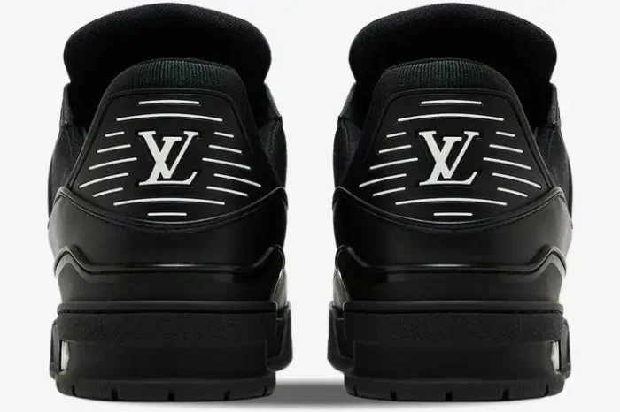 Rear view of Louis Vuitton LV Trainer sneakers in all black leather with white logos on the heels. - SKU 1A9JG9