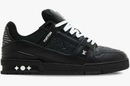 Side profile of the Louis Vuitton LV Trainer in black leather with white laces and monogram details. - SKU 1A9JG9