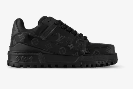 Side profile of a black Louis Vuitton LV Trainer sneaker featuring embossed monogram leather and a thick sole. - SKU 1AHDBK