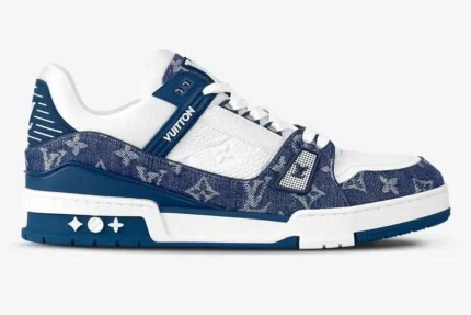 Side profile of a Louis Vuitton LV Trainer sneaker in white leather and blue monogram denim. - SKU 1A9JGR