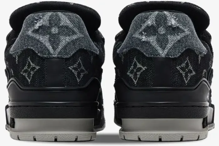 Rear view of Louis Vuitton LV Trainer Monogram Black White sneakers with denim monogram heel tabs and black midsoles. - SKU 1ACFS1