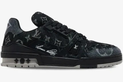 Side profile of a Louis Vuitton LV Trainer sneaker in black and white monogram denim. - SKU 1ACFS1