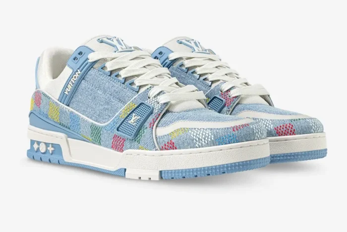 Louis Vuitton LV Trainer sneakers in light blue monogram denim damier, three-quarter front view. - SKU 1AHCYB