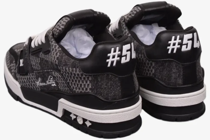 Rear view of Louis Vuitton LV Trainer sneakers in black and white plaid with #54 heel detail. - SKU 1A9ZAY