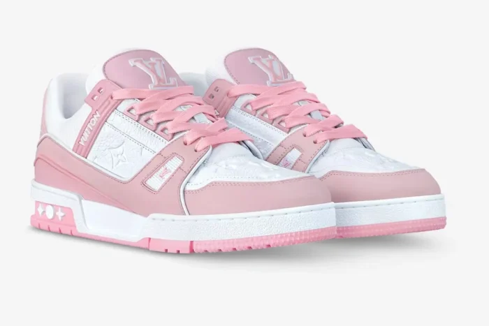 Pair of Louis Vuitton LV Trainer rose pink and white women's sneakers in a three-quarter side view. - SKU 1AAW59