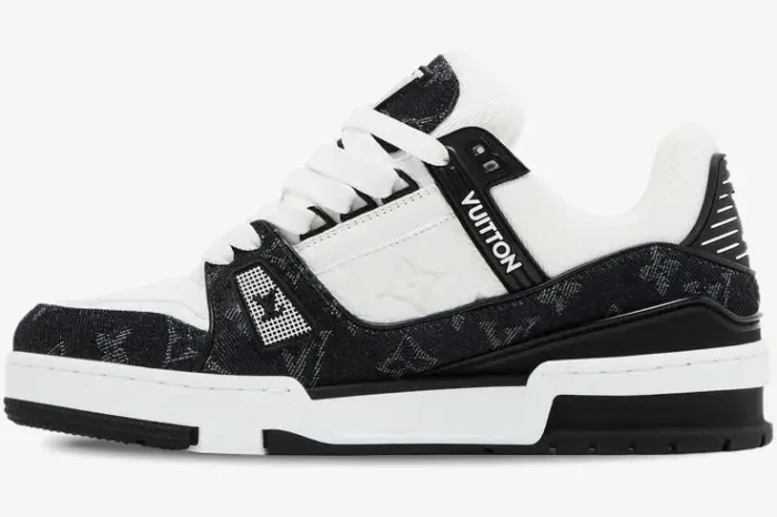 Side profile of a Louis Vuitton LV Trainer in white and black monogram denim with a chunky sole. - SKU 1A9JG9