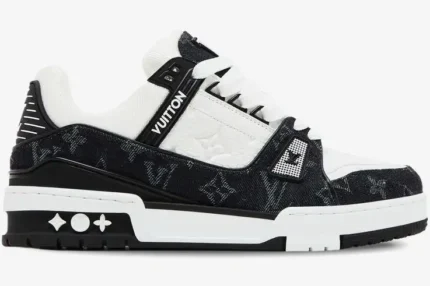 Side view of a Louis Vuitton LV Trainer sneaker in white and black monogram denim. - SKU 1A9JG9