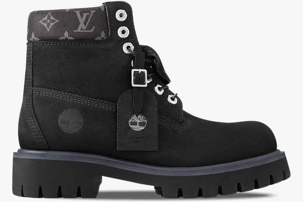 louis-vuitton-timberland-6-inch-boot-black-side-1ad75a-379-076 Side profile of a black Louis Vuitton x Timberland 6-inch ankle boot with monogram collar and silver hardware. - SKU 1AD75A