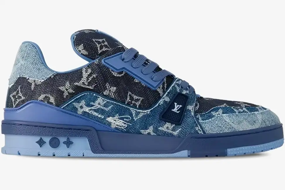 louis-vuitton-trainer-denim-blue-side-view-1ac4yn-741-20260111_183650 Side view of Louis Vuitton Trainer Monogram Denim Blue sneaker with textured denim and blue sole. - SKU 1AC4YN
