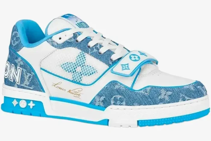Side profile of a Louis Vuitton Trainer Low in light blue monogram denim and white leather with a velcro strap. - SKU 1A9J1N