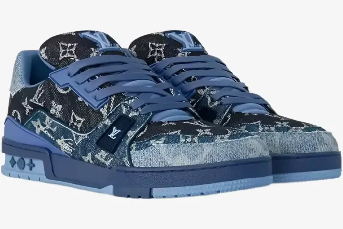 Louis Vuitton Trainer Monogram Denim Blue sneakers shown from a three-quarter front angle. - SKU 1AC4YN