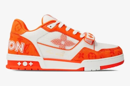 Side profile of a Louis Vuitton Trainer in orange monogram denim and white leather with a velcro strap. - SKU 1A9ZBI