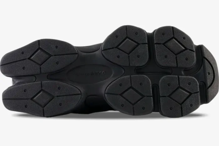 Bottom view of the New Balance 9060 Triple Black sneakers showing the chunky black rubber outsole tread pattern. - SKU U9060BPM