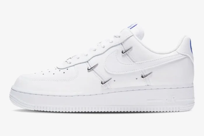 Side view of white Nike Air Force 1 '07 LX Chrome Deluxe women's shoes with silver charms and blue accents. - SKU CT1990-100