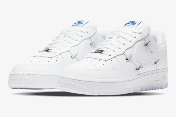 Nike Air Force 1 '07 LX Chrome Deluxe Women's sneakers in white with silver mini swooshes, three-quarter view. - SKU CT1990-100
