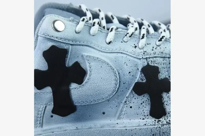 Close-up of a custom light blue Air Force 1 with black Chrome Hearts leather crosses and patterned laces.