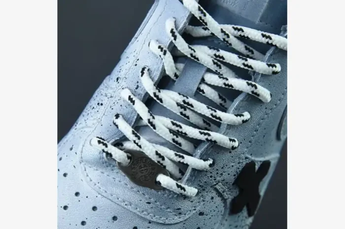 Close-up of custom light blue Air Force 1 Chrome Hearts sneakers with patterned laces and metal lace dubrae.
