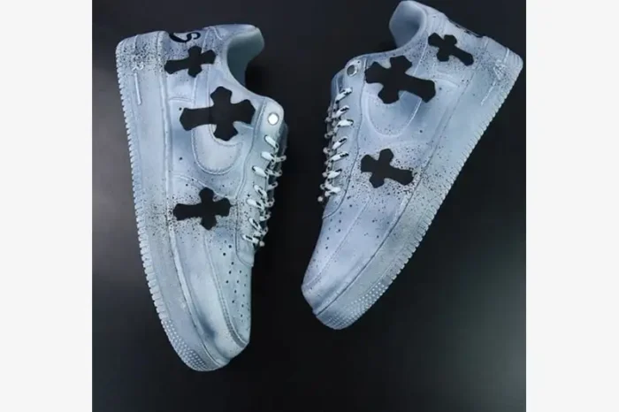Top-down view of custom light blue Air Force 1 sneakers with black Chrome Hearts style crosses and paint splatters.