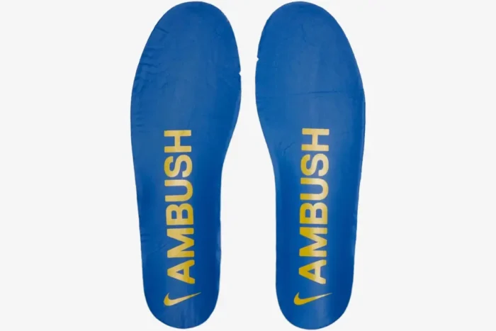 Top-down view of blue Nike Air Force 1 Low x Ambush insoles with yellow branding. - SKU DV3464-400