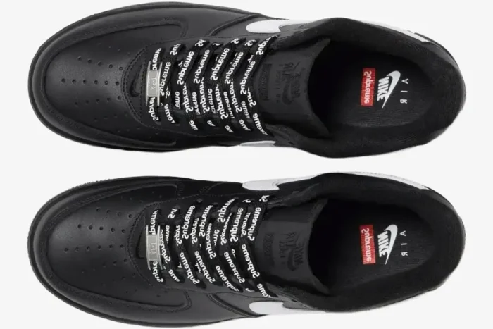 Top-down view of black Nike Air Force 1 Low x Supreme sneakers with branded laces. - SKU SP1AF11