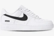 Side profile of a white Nike Air Force 1 Low x Supreme sneaker with a black swoosh and box logo. - SKU SPNK1AF3