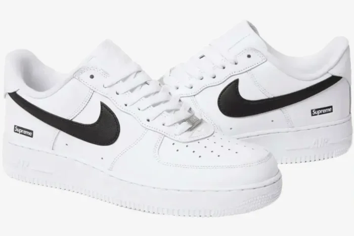 Nike Air Force 1 Low x Supreme White sneakers with black Swoosh, three-quarter side view. - SKU SPNK1AF3