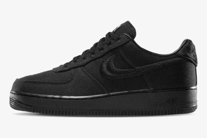 Side profile of the Nike Air Force 1 Low x Stussy Triple Black Hemp sneaker with embroidered Swoosh. - SKU CZ9084-001