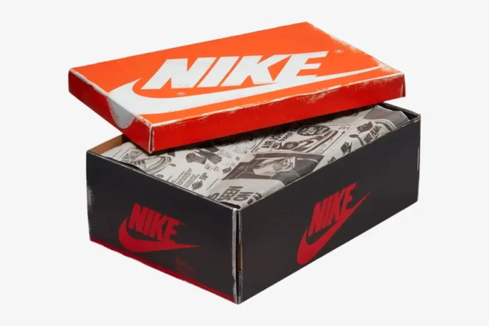 Distressed Nike shoebox for Air Jordan 1 Chicago with orange lid and newspaper wrapping paper, angled view. - SKU 555088-101