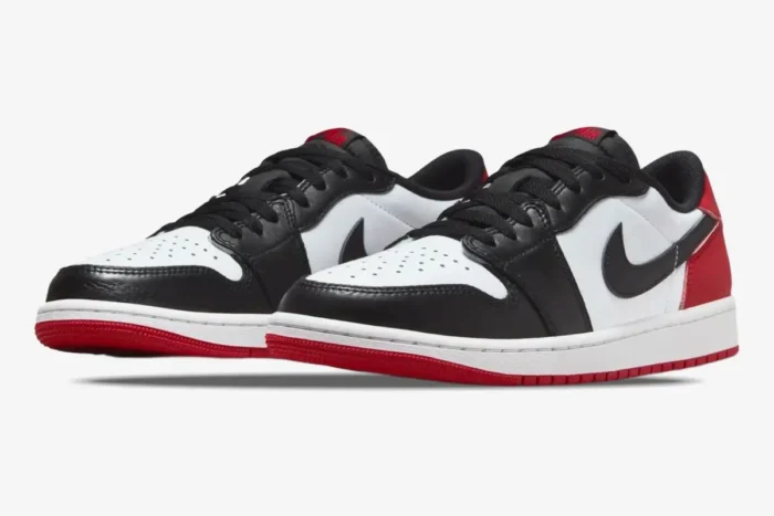 Air Jordan 1 Low Black Toe sneakers in white, black, and red, shown from a three-quarter front angle. - SKU 553558-116
